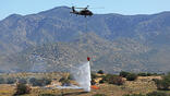 Black Hawk helicopter drops water on a fire