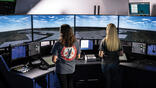 Two people standing in air traffic control room