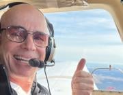 Patrick Milando giving a thumbs up while piloting aircraft