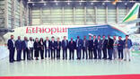 Group standing in front of Ethiopian Airlines jet and sign