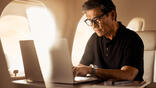 a man at a laptop using Wi-Fi on a Vista aircraft