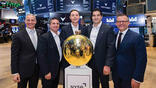 Five men standing around the bell at the New York Stock Exchange