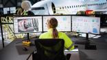 Technician in front of computer screens in aircraft hangar