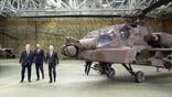 Paweł Bejda, Minister for National Defense, Władysław Kosiniak-Kamysz, Deputy Prime Minister and Polish Prime Minister Donald Tusk (L-R) are framed by an Apache attack helicopter