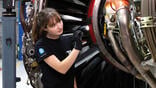 mechanic studying engine with flashlight