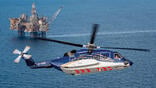 Sikorsky S-92 aircraft flying with offshore oil rig in background
