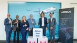 Airbus employees in front of signs for the new tech hub in Canada